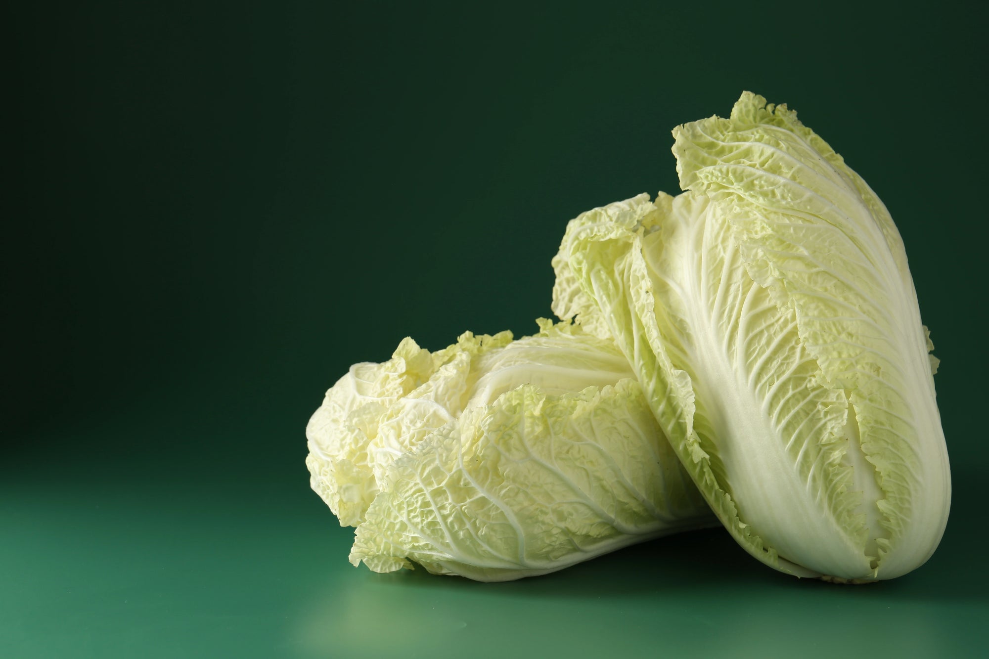 Two pieces of green cabbage on a green background