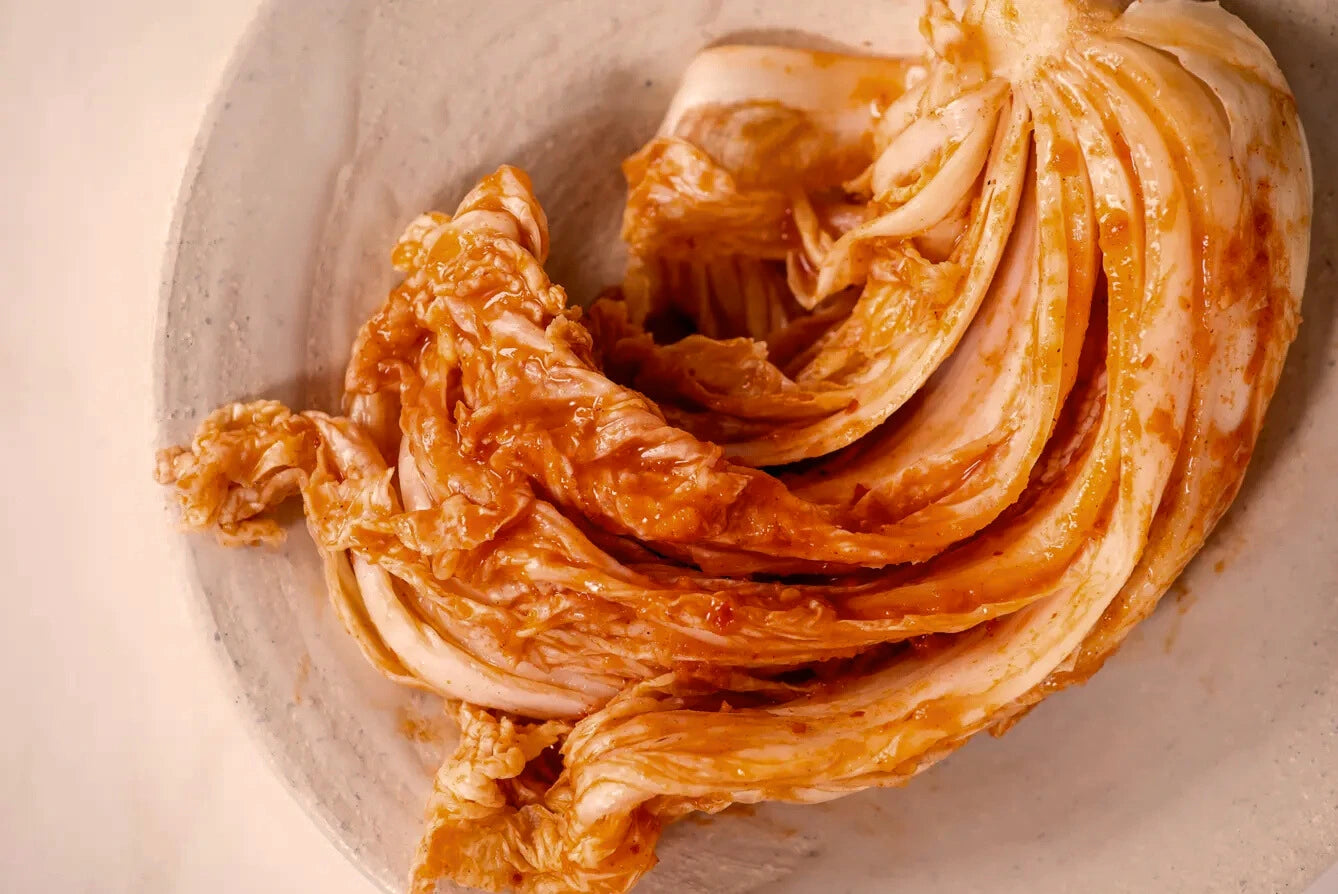 Noodles with a red sauce in a gray bowl on a beige background