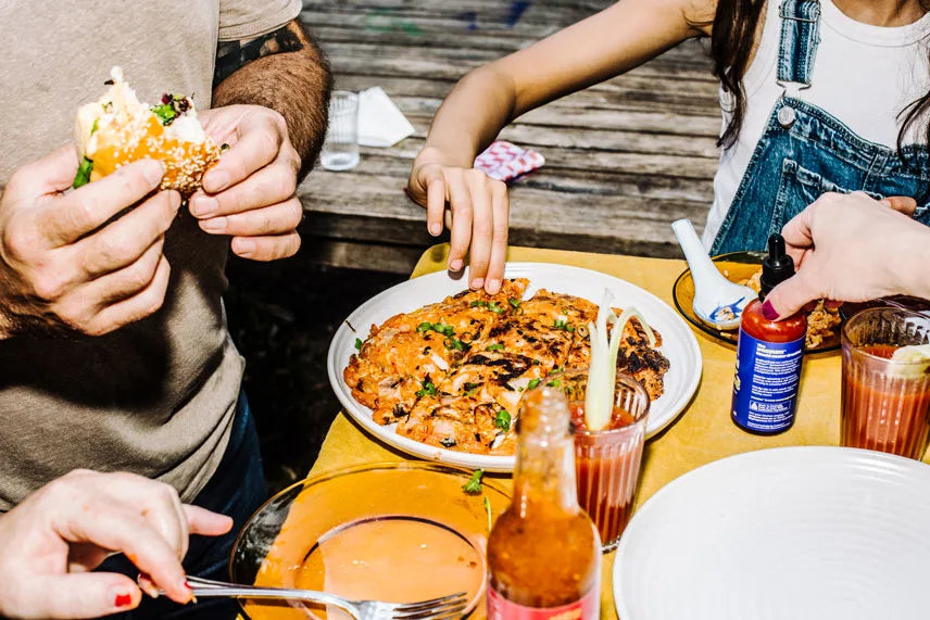 People enjoying a meal together at a table with food and drinks.