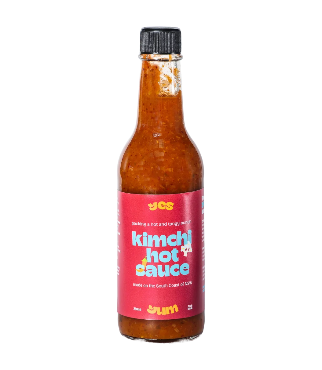 Bottle of kimchi hot sauce with a red label on a white background