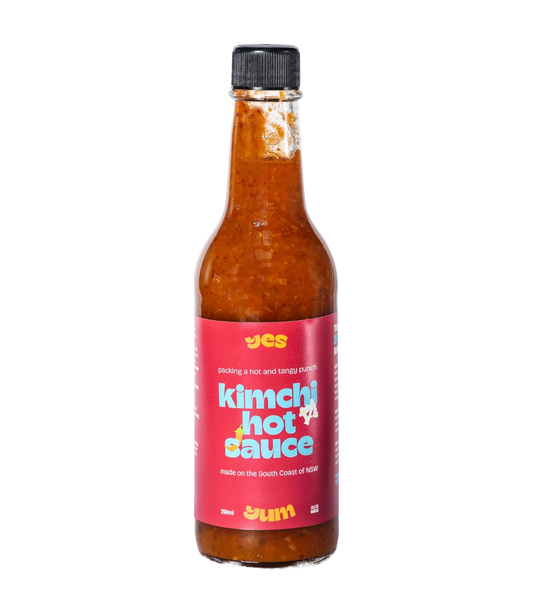 Bottle of kimchi hot sauce with a red label on a white background
