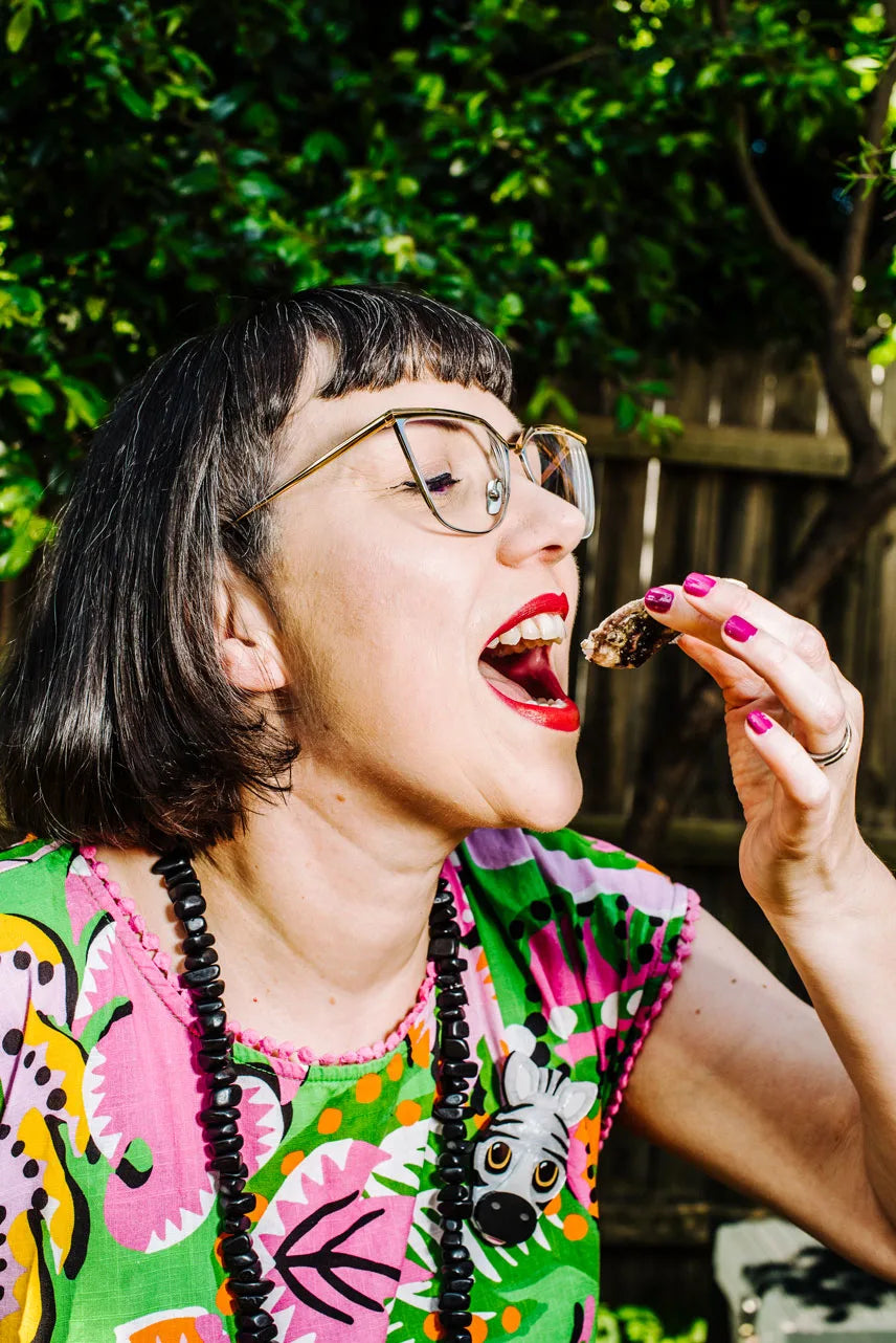 Person eating outdoors with a colorful shirt and glasses