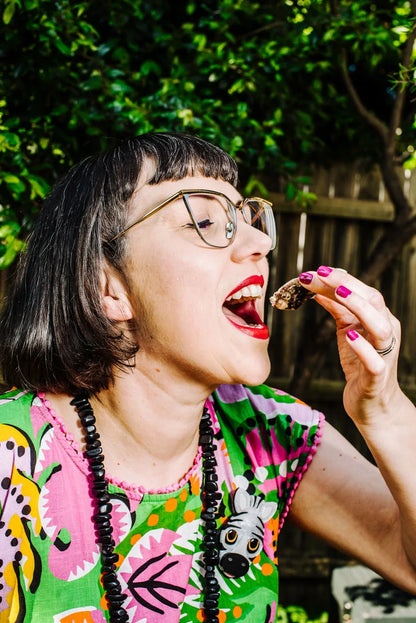 Person eating outdoors with a colorful shirt and glasses
