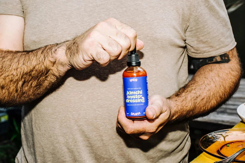 Person holding a bottle of kimchioyster dressing