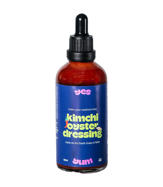Bottle of kimchi oyster dressing with a blue label on a white background