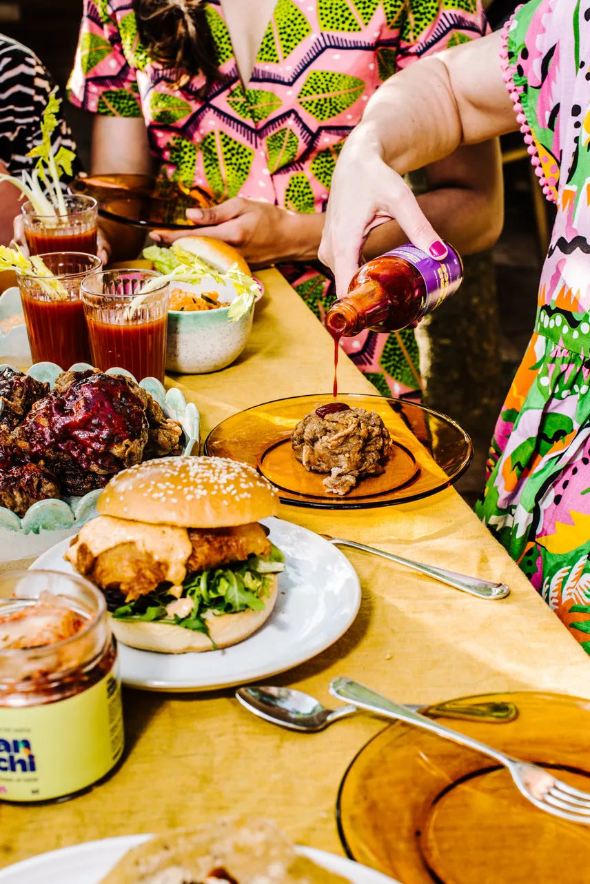 People enjoying a meal with burgers and drinks at a table.