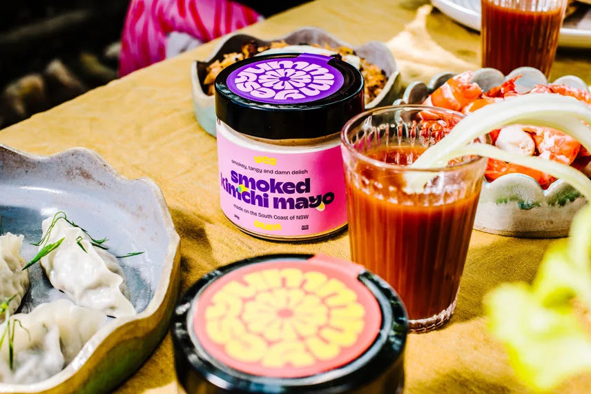 Smoked sriracha mayo container on a table with food and drinks